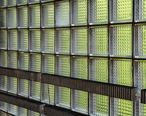 Transparent glass wall blocks with a green tint, stacked in the wall