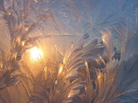 Ice pattern and sunlight close up on window glass