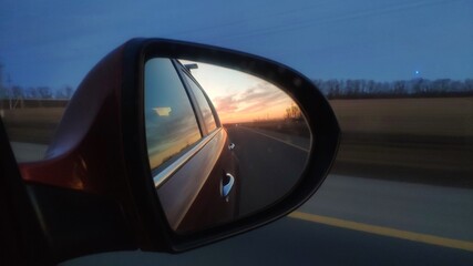 sunset in the car rearview mirror