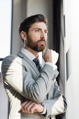 Portrait of businessman in formal wear looking away in office.