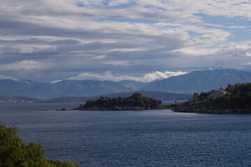 Fototapeta na wymiar Cape on the sea. Greece. Mountains in the background. 