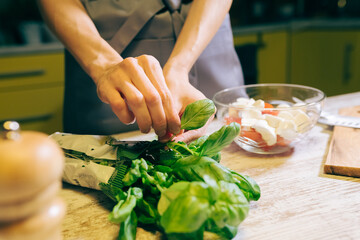 Pretty woman cooking salad at kitchen. Housewife preparing dinner at home