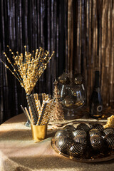 Festive decorations on table setting in black and gold colors to celebrate the new year and christmas party