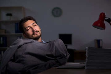 Young male employee working late in the office