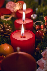 Three burning red candles on Advent wreath