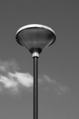 Clean lines of a modern lamppost silhouetted against an even sky in black and white.