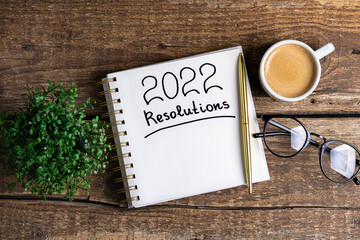 New year resolutions 2022 on desk. 2022 new year resolutions on wooden table with coffee cup,...