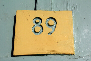 Number 89 carved in wooden sign, close-up