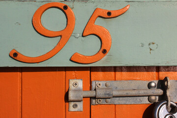 Number 95 embossed in wooden sign, in a beach hut, Brighton, UK, close-up	