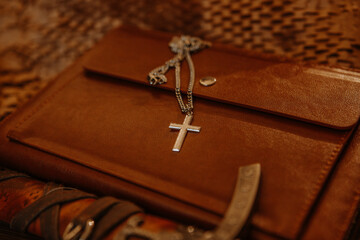 Cross chain necklace product photography with brown setting journal and sword 