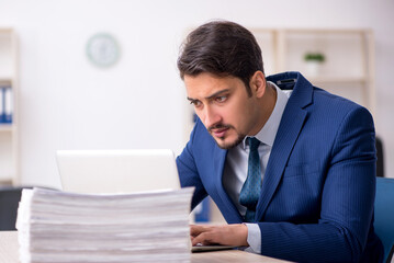 Fototapeta premium Young male employee and too much work in the office