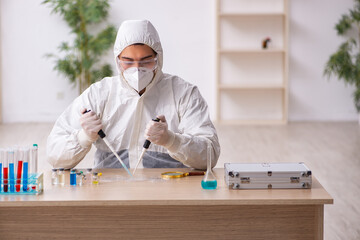 Young male chemist working at the lab during pandemic