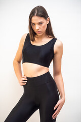 High fashion portrait of young fit elegant woman wearing black clothes. 