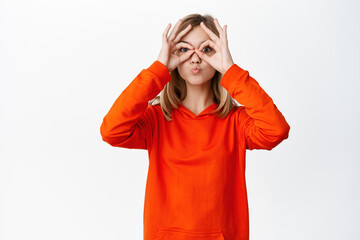 Okay. Happy smiling blond little girl showing ok, approve gesture, like smth good, praising, complimenting and recommending kids store, white background