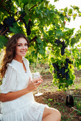 beautiful blonde woman with a glass of wine in the vineyard