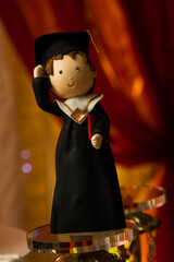 Graduation cake doll with diploma toga - obrazy, fototapety, plakaty