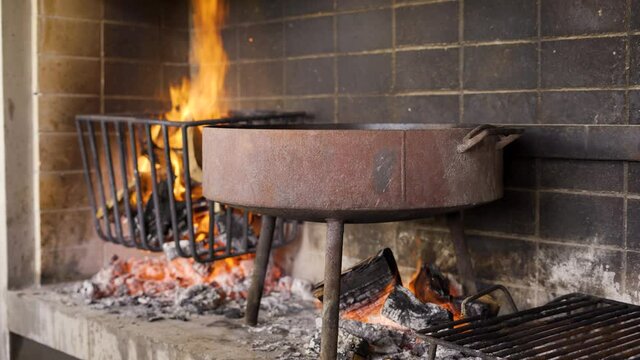 Chef trabajando con fuegos para la preparaci&oacute;n de un t&iacute;pico asado argentino