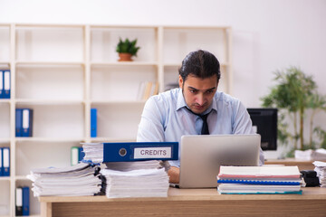 Young male employee and too much work in the office