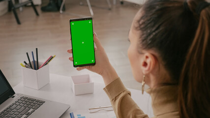 Close up of woman vertically holding green screen on smartphone. Mobile phone with chroma ky...