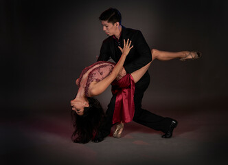 tango ballroom tango couple of latin woman and asian man, studio shot black background - obrazy, fototapety, plakaty