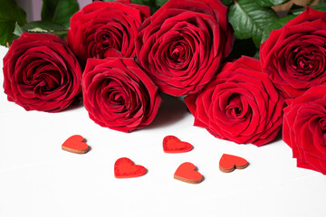 red roses, and heart on white table