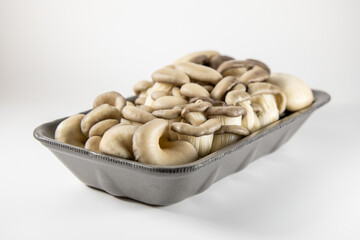 Pleurotus ostreatus packed in a foamed polystyrene tray, ready-to-sell mushrooms. White background. Safely packaged product