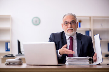 Old male employee working in the office