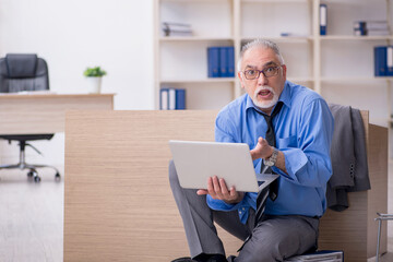 Old male employee unhappy with excessive work in the office