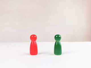 Two wooden figures stand on the table against white background. Business opponents concept.