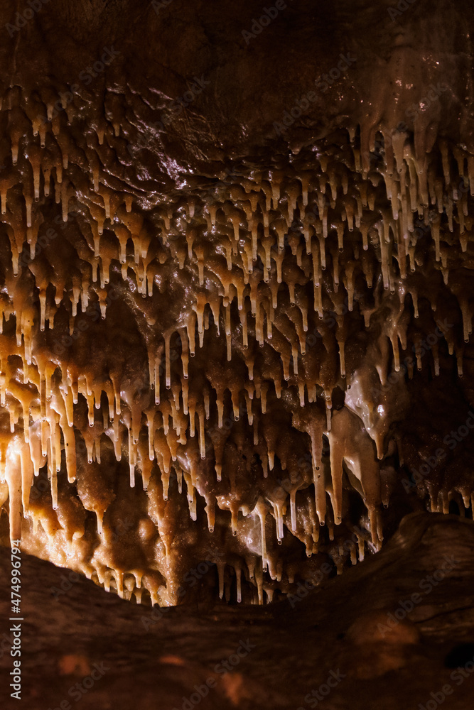 Wall mural detail of stalactites in a cave on the ceiling.