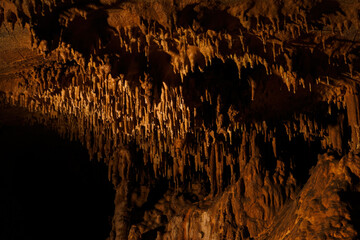 Detail of stalactites in a cave on the ceiling.