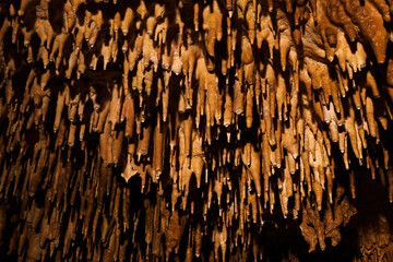 Detail of stalactites in a cave on the ceiling.