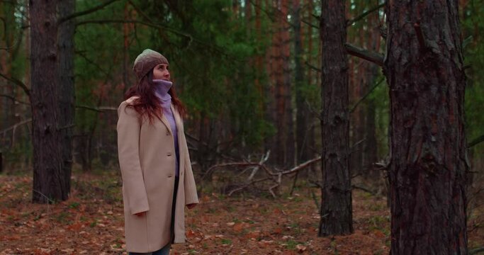 Young woman stands in a coniferous forest and breathes clean air, clean ecology. Happy woman enjoys the nature of a coniferous forest, fresh clean air. 4k, ProRes