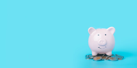 Pink piggy bank on blue background with copy space, saving and investing Financial management and bank, wealth and financial concept.