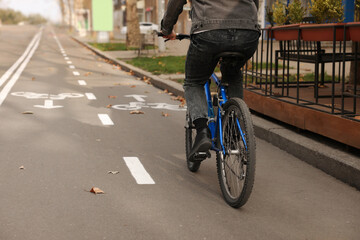 Man riding bicycle on lane in city, closeup