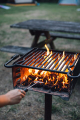 outdoor bbq grill with fire flames at picnic campsite 