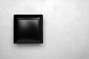 Black light switch on grey background, top view. Space for text