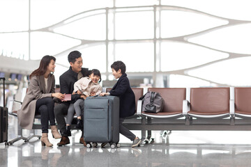 Happy young family waiting for flight at the airport