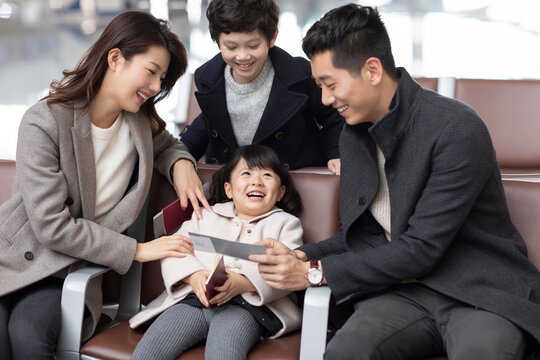 Happy young family waiting for flight at the airport