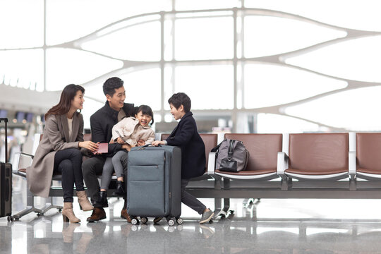 Happy young family waiting for flight at the airport - Powered by Adobe