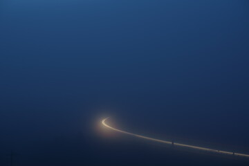 濃霧の中を走る自動車の光跡