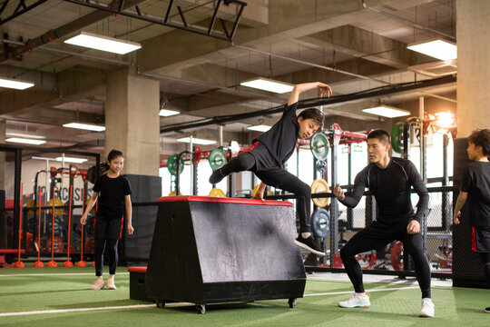 Active children having exercise class with their coach in gym