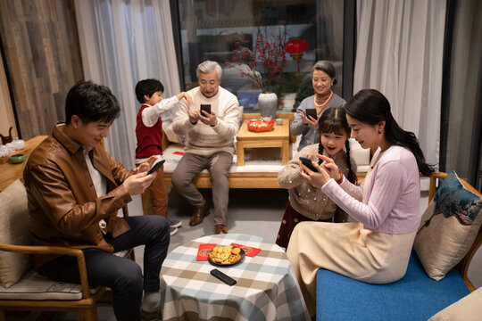 Happy family grabbing red envelope with smart phones