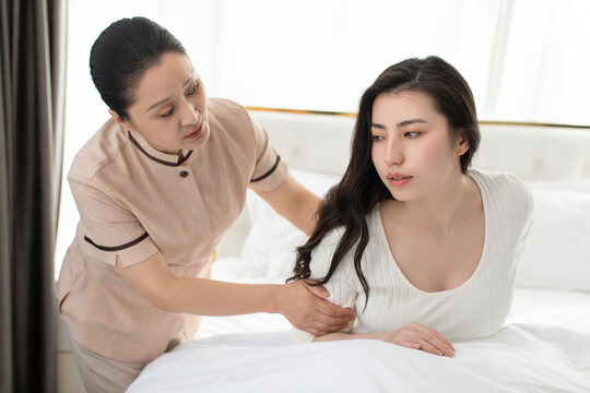 Confinement nurse taking care of young woman