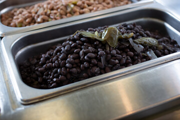 A view of a steamer tray of black beans.