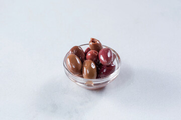 A view of a glass condiment bowl of Kalamata olives.