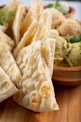 A closeup view of a platter of pita bread and hummus.