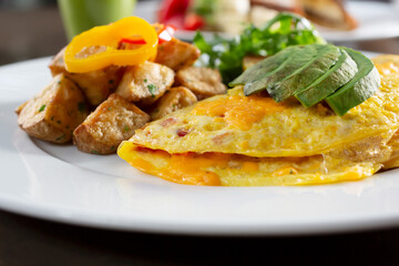 A view of an omelet plate, with a side of roasted potatoes.
