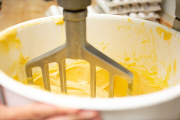 A closeup view into a commercial grade stand mixer, kneading bread dough, seen at a local bakery.