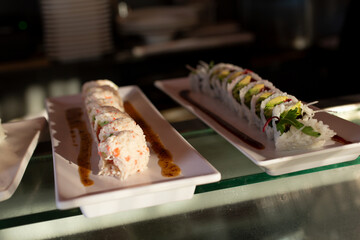 A view of sushi rolls that are ready and waiting to be picked up on a counter, seen at a local restaurant.